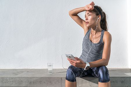 woman sweating and listening to music on her headphones