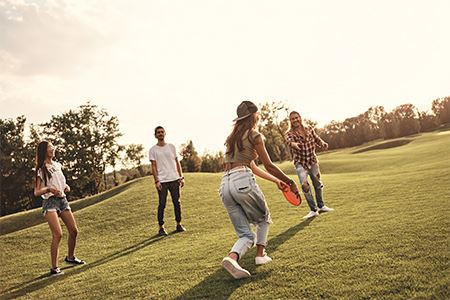 4 teens playing with a Frisbee in the park